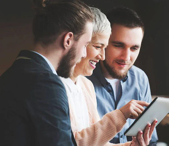 Three colleagues reviewing information together on a tablet