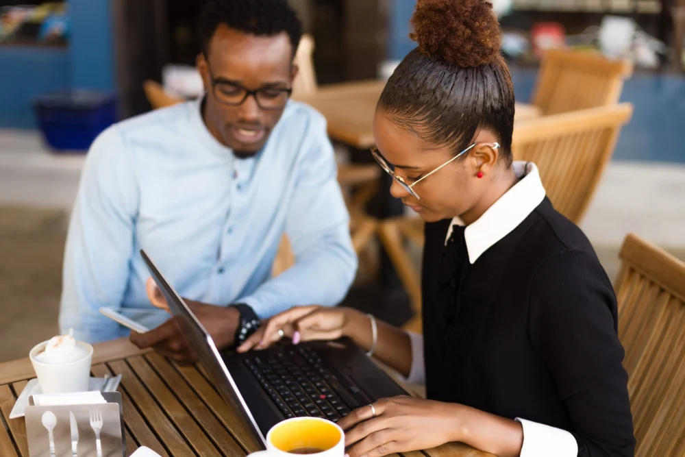 Two business professionals collaborating with a laptop and tablet