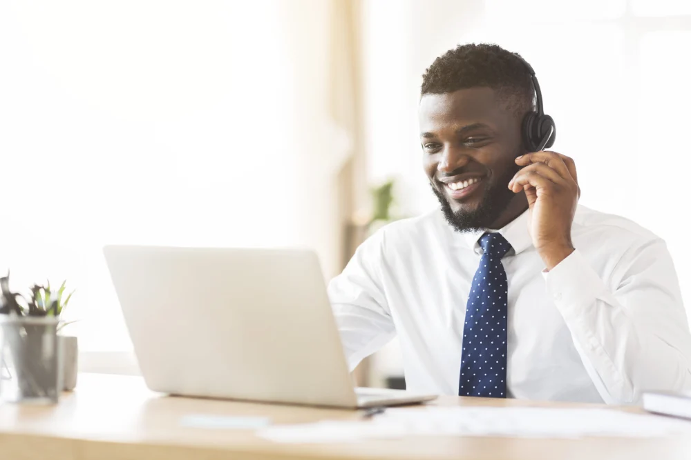 A consultant supporting a conversation using a headset and laptop